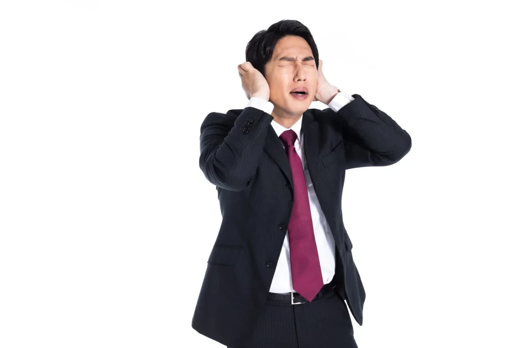 耳をふさぐ男性